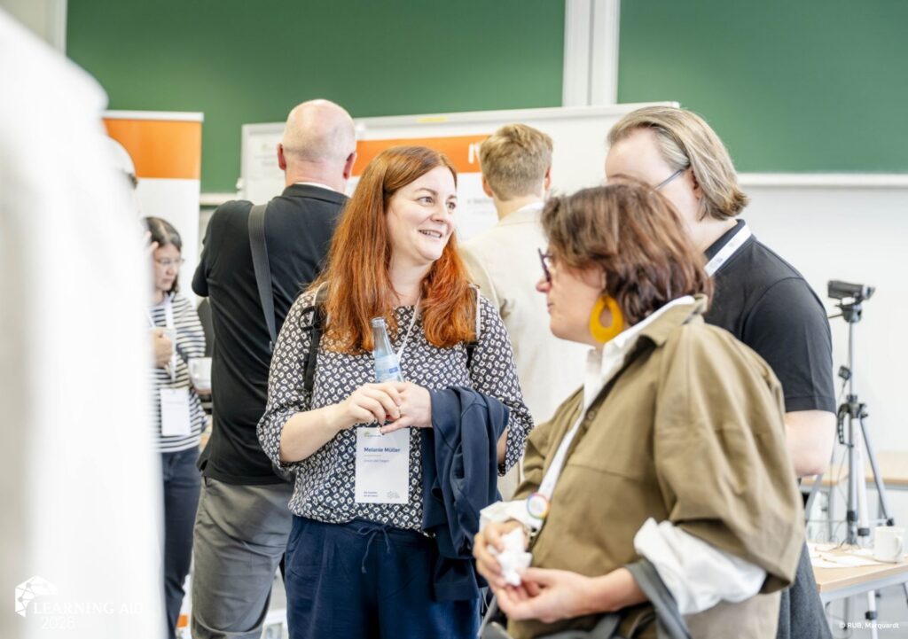 Learning AID Teilnehmer:innen unterhalten sich bei Poster-Sessions