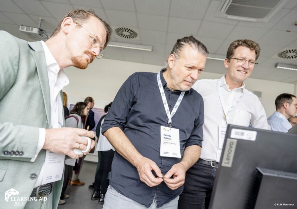 Learning AID Teilnehmer:innen schauen auf einen Monitor